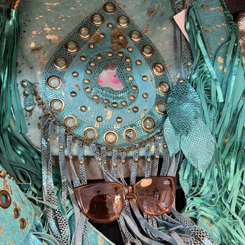 Bolso piel turquesa con flecos, detalles dorados y piedra central